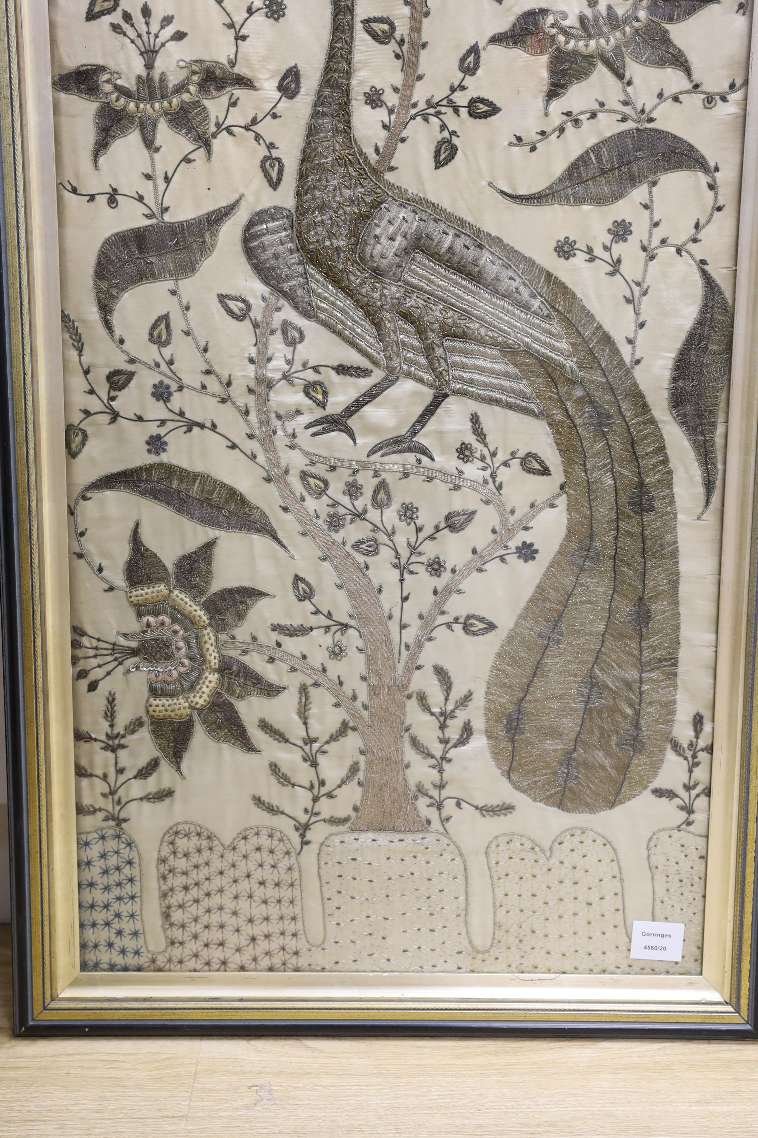 A framed large 19th century Indian embroidered panel decorated with a peacock and flowers 108x49cm